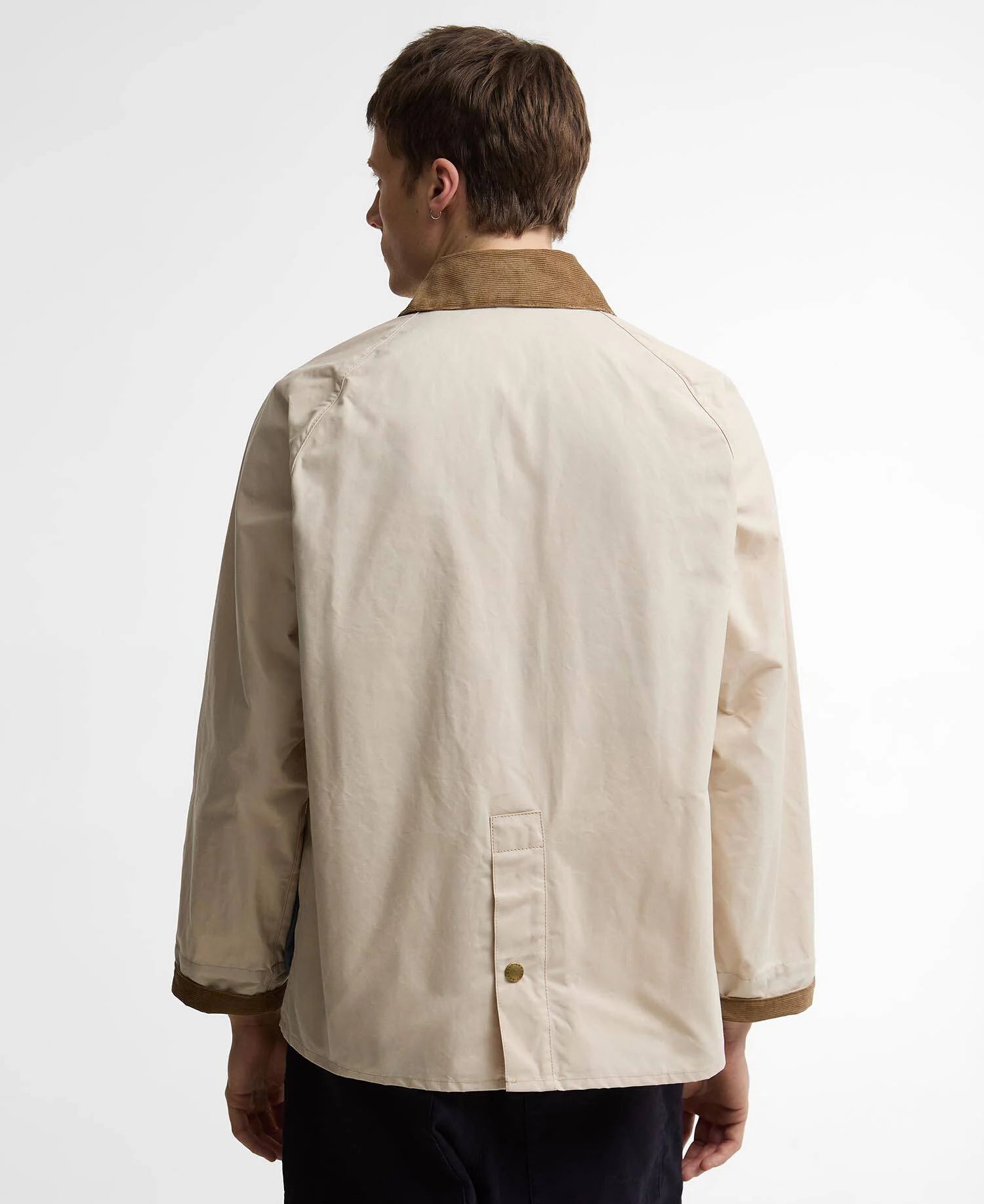 Person wearing a beige jacket with a brown collar on a white background
