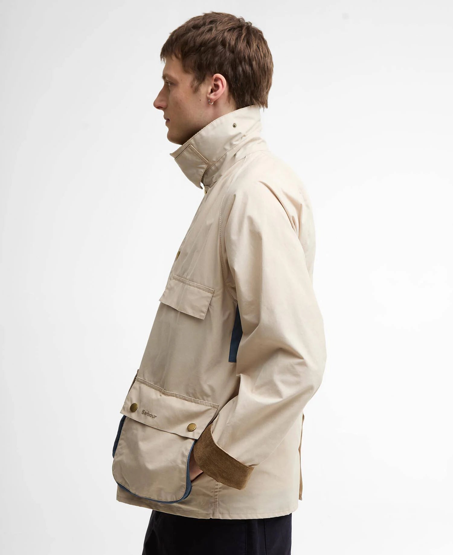 Man wearing a beige jacket on a plain background