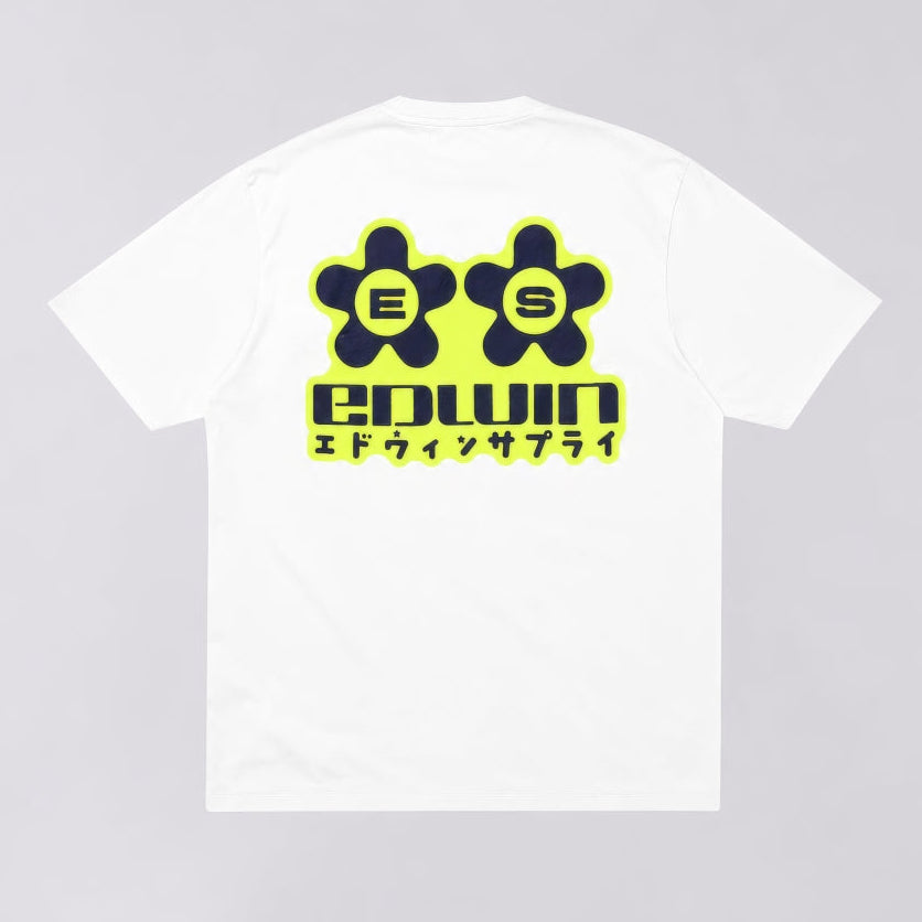 A white short-sleeve t-shirt with a large graphic on the back. The graphic features two dark green flower-like shapes with the letters 'E' and 'S' inside, outlined in neon yellow, above the word 'edwin' in dark green with a neon yellow outline, and Japanese katakana text underneath.